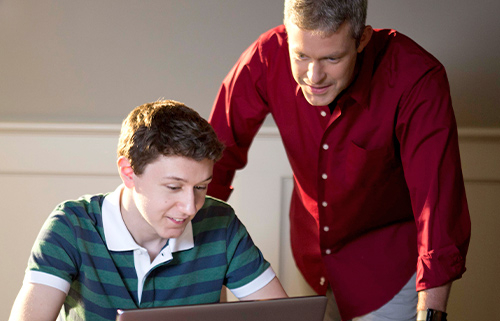 Father and son working on a laptop